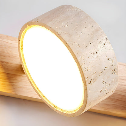 Stone-look LED wall light shade with glowing warm light on a wood-look bar