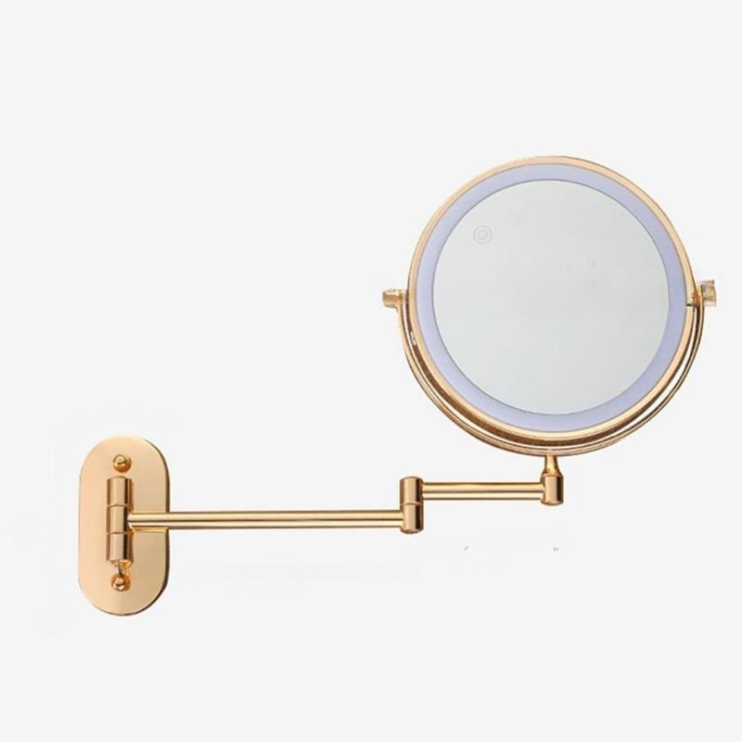Wall-mounted round cosmetic mirror with gold frame, LED ring, and horizontal support arm