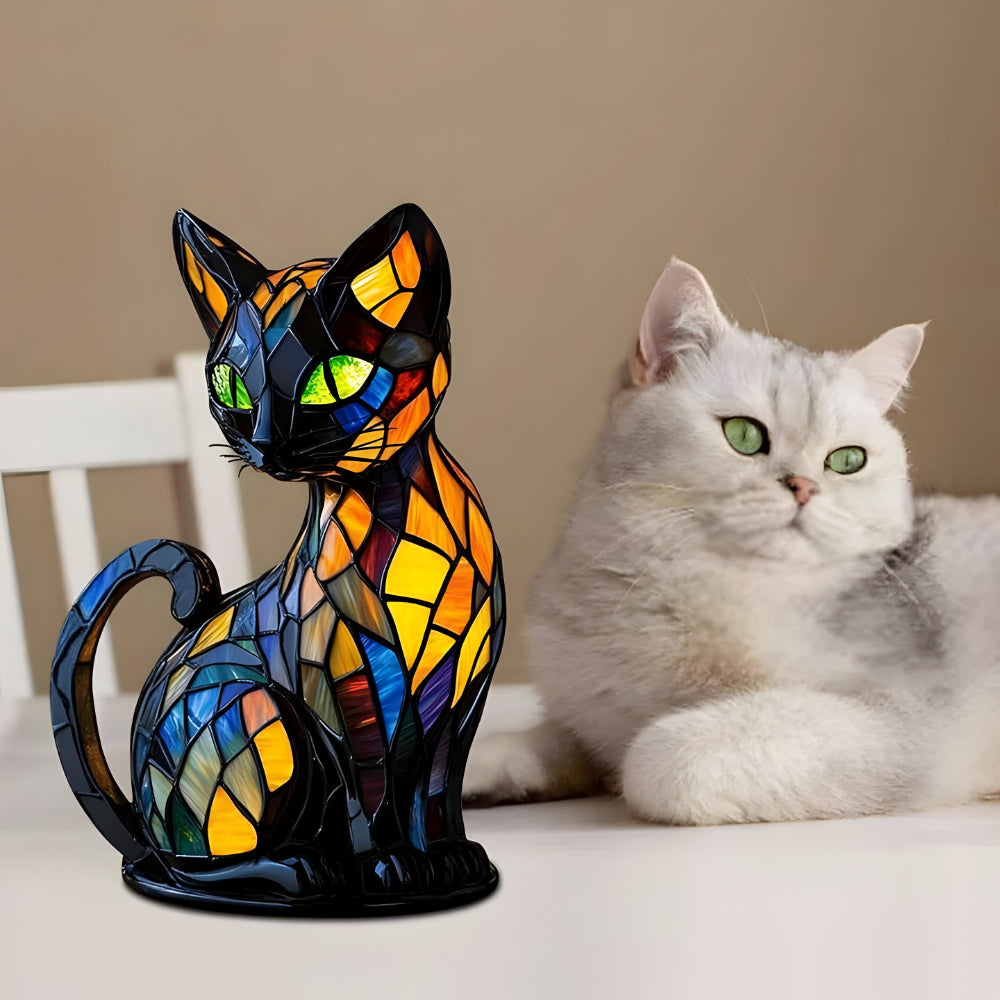 Stained glass cat table lamp beside a white cat on a couch