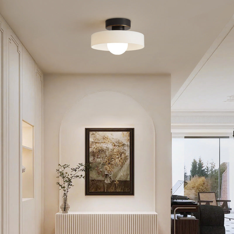 Round ceiling light with black metal base and frosted white glass shade.