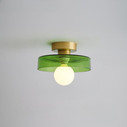 Ceiling light with round green glass shade and gold metal top, glowing bulb