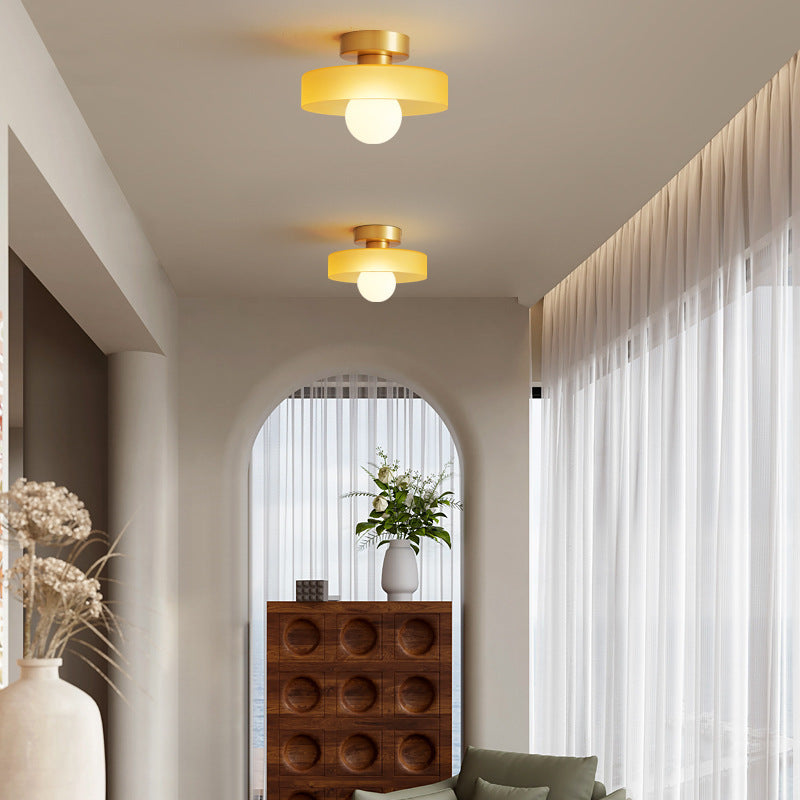 Round ceiling light pair with amber glass shades and gold bases.