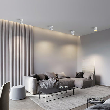 Multiple small LED ceiling lights with metal shades in a bright living room.