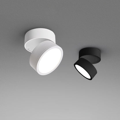 White and black LED ceiling spotlights side-by-side with warm illuminated lenses.
