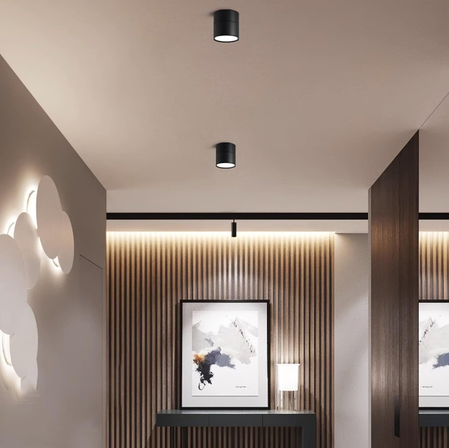 Small black LED ceiling lights with cylindrical shades in a modern interior.