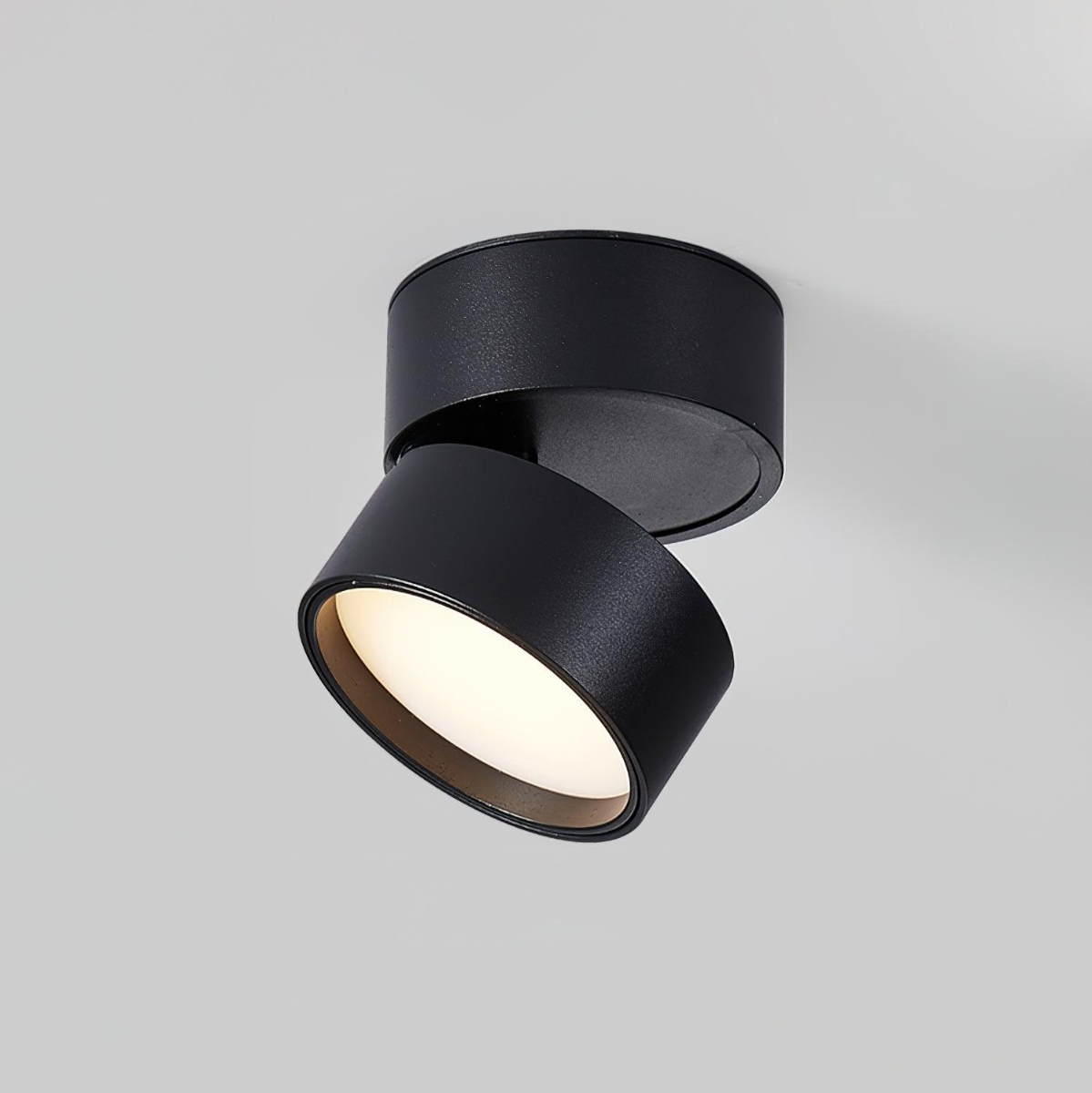 Black LED ceiling spotlight with textured round canopy and warm glowing ring.