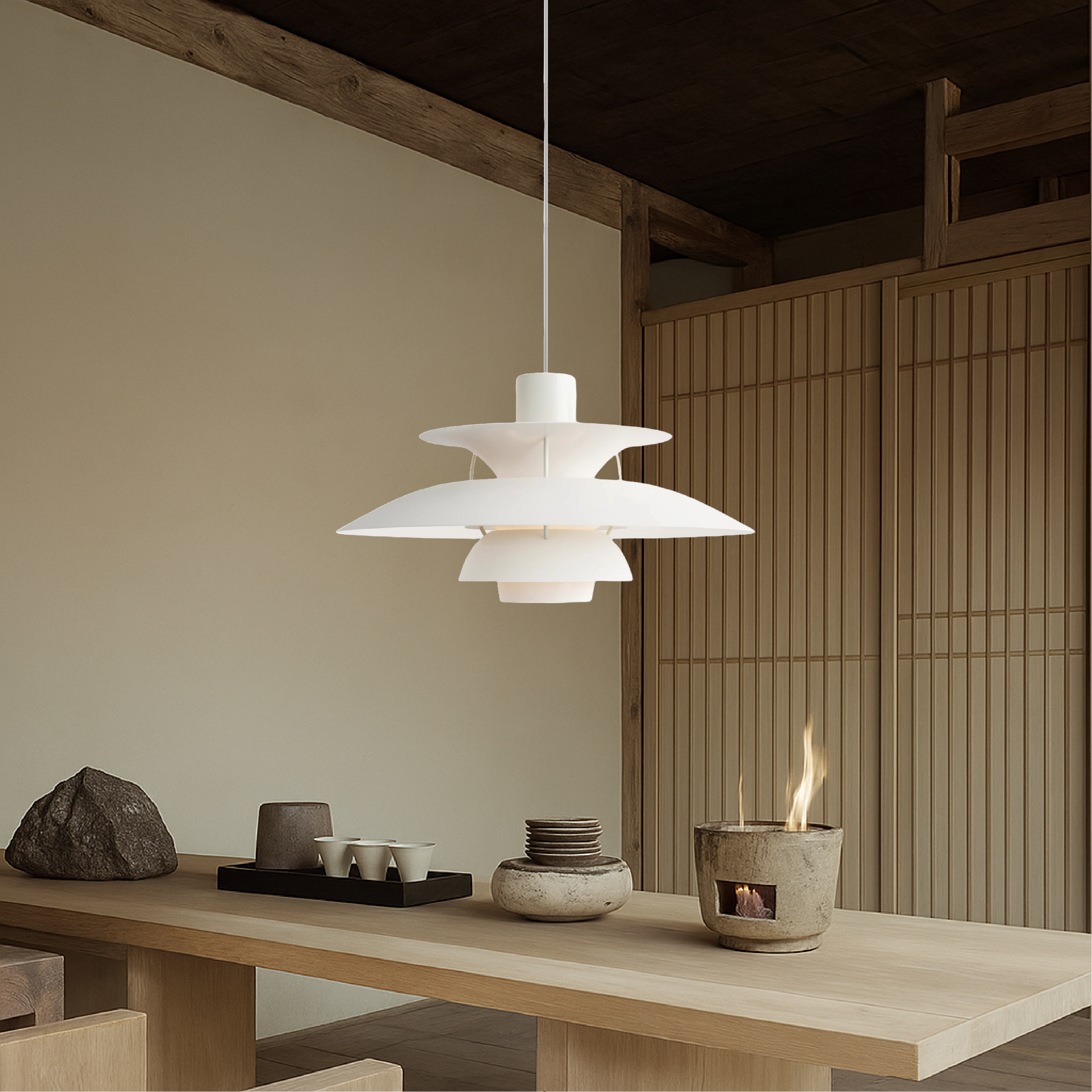 White pendant light with layered bell shades and white diffuser, hanging in dining room