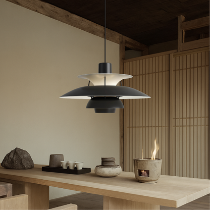 Black aluminum pendant light with tiered bell shades and white inner diffuser, hanging over table