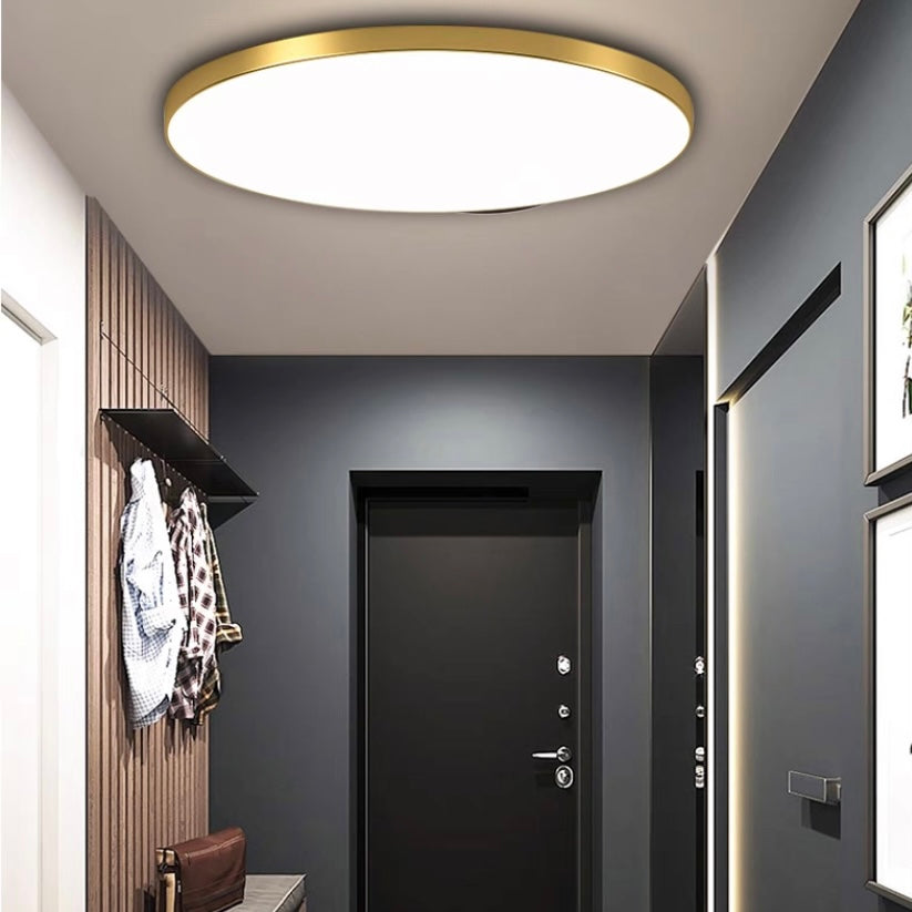 Gold-toned round flat LED ceiling light with white acrylic diffuser panel
