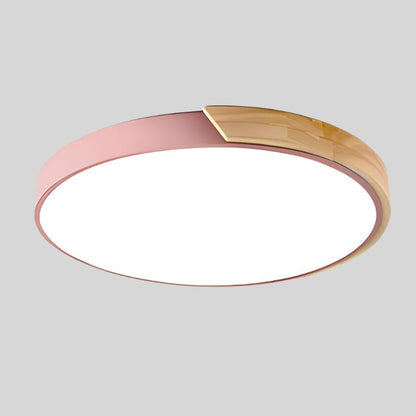 Round ceiling light with white acrylic diffuser and pink metal rim, warm wood accent