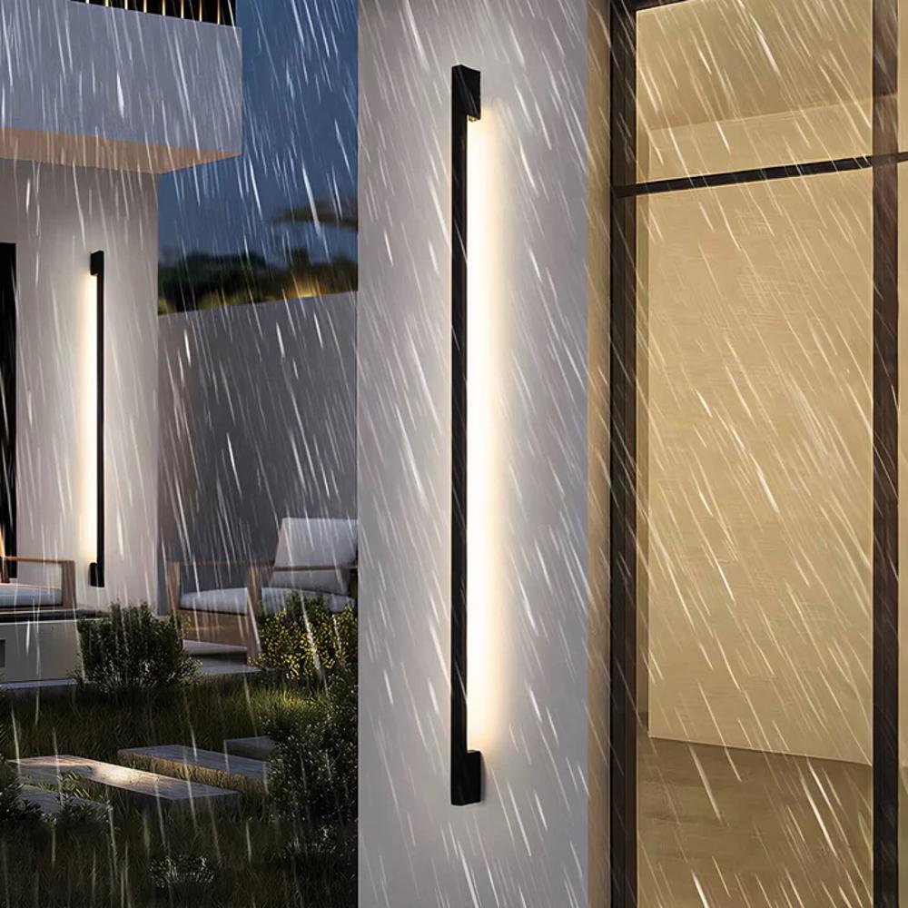 Slim dark LED wall light strip with white glow, shown mounted on an exterior wall