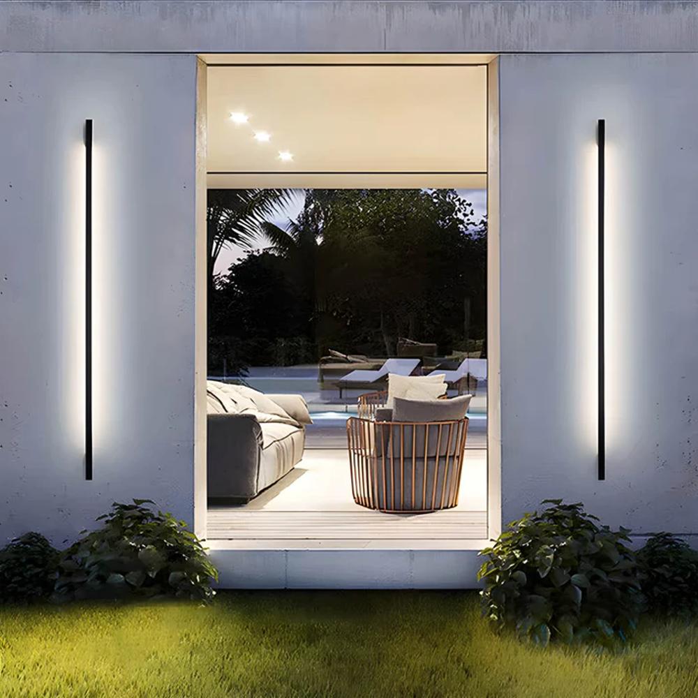 Exterior wall-mounted LED light strip with slim dark housing, producing a white glow