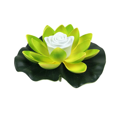 Floating lotus LED pond light with green petals and a white center on dark green leaves