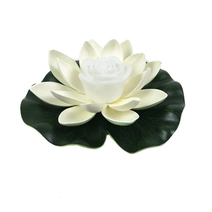 Floating lotus LED pond light with white petals, white center, and dark green leaves