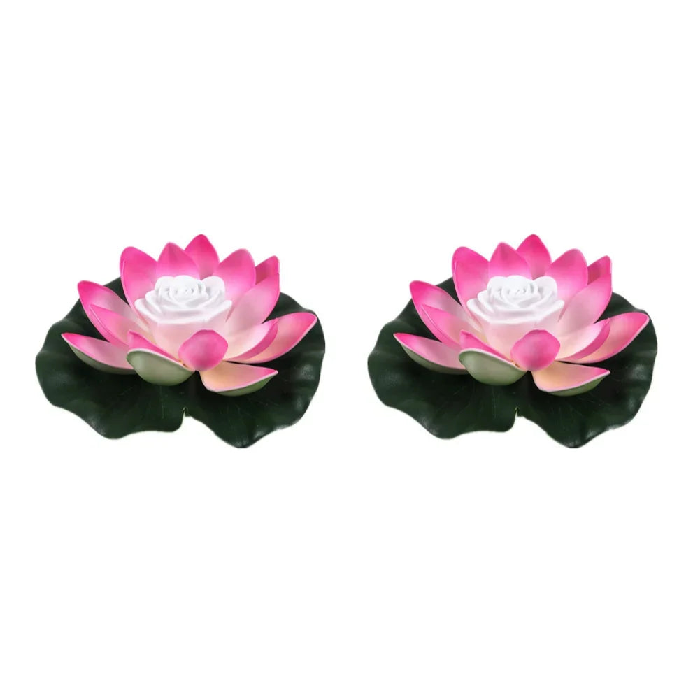 Pair of floating lotus LED pond lights with pink petals, white center, and dark green leaves
