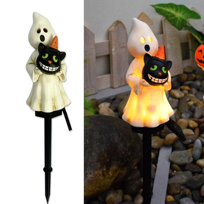 Glowing ghost and pumpkin solar garden light pair on black stakes in garden