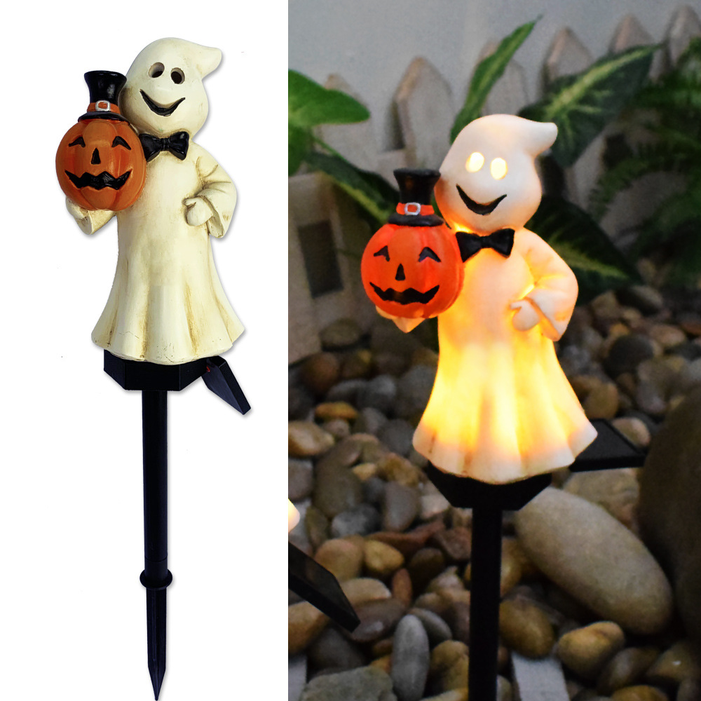 Glowing ghostly figure solar garden light holding a jack-o-lantern on black stake