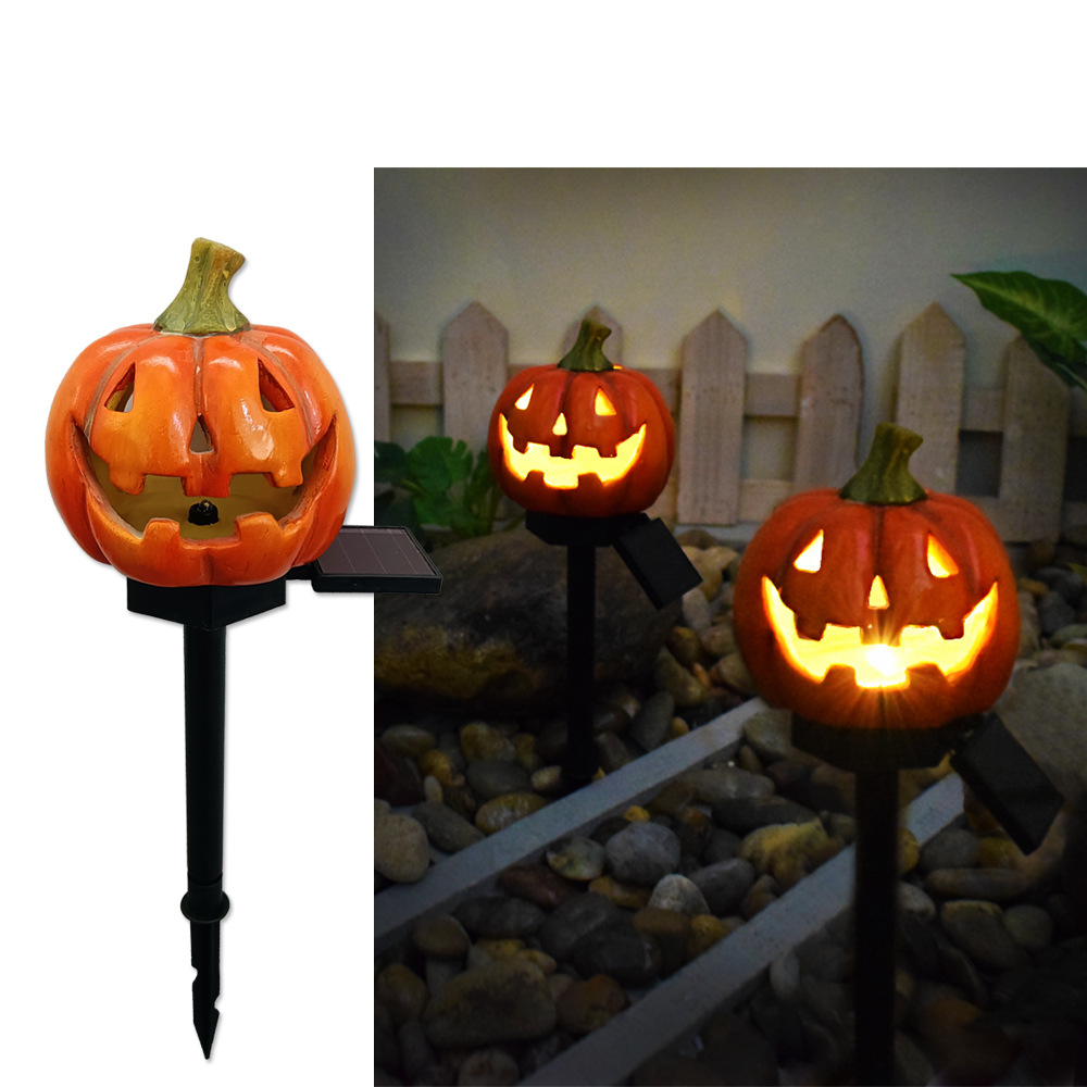 Carved pumpkin solar garden light with glowing jack-o-lantern face on black stake