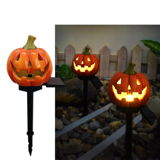 Carved pumpkin solar garden light with glowing jack-o-lantern face on black stake